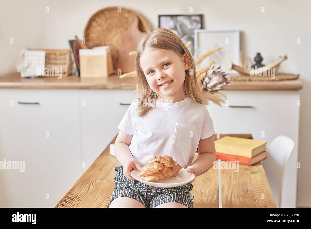 Buon bambino. Ragazza in cucina. Giorno dei bambini e delle madri. Buona mattina e colazione. Foto Stock