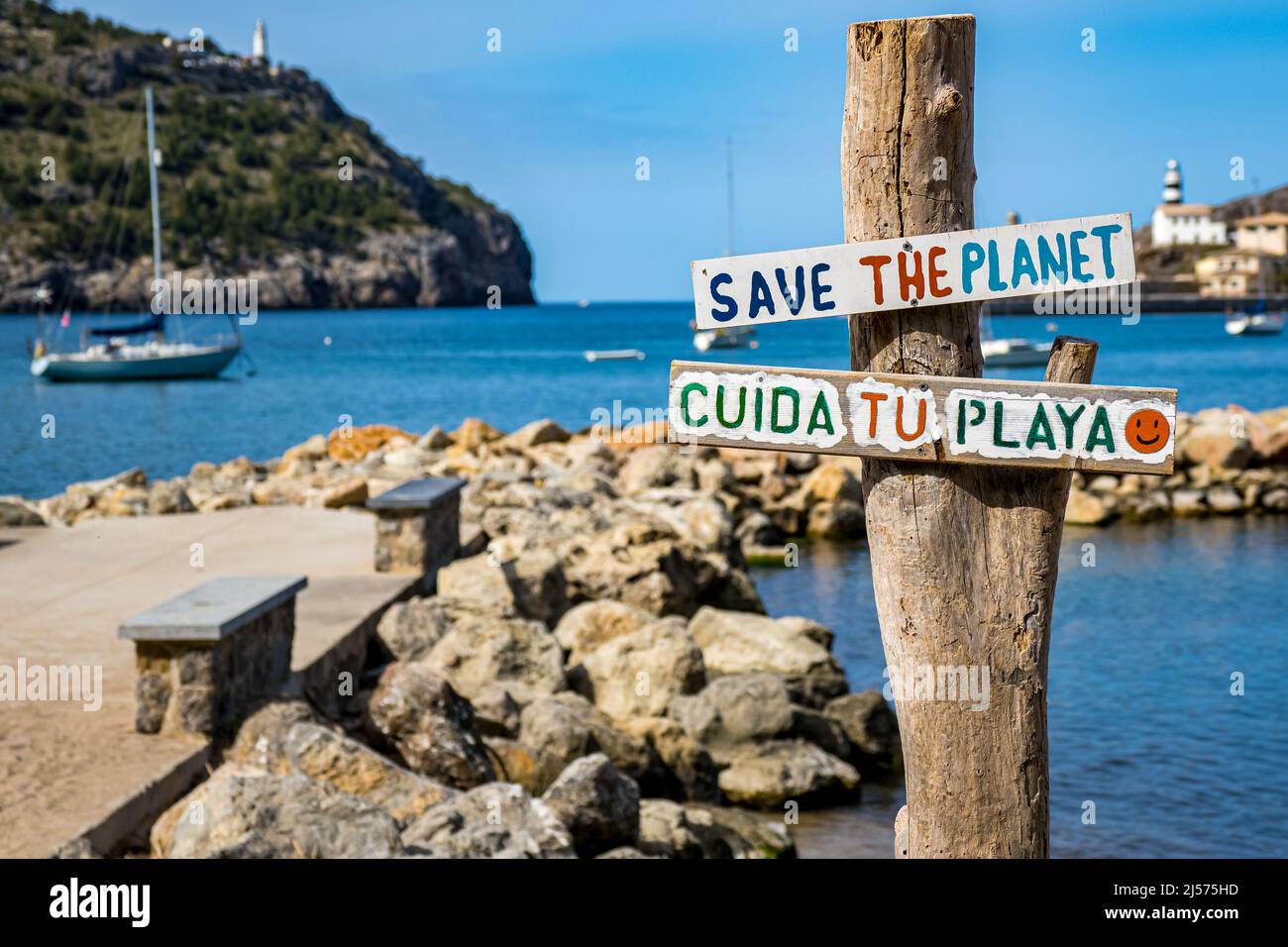 Sicuro il pianeta e Cuida tu playa scritto su un asse (prendersi cura della vostra spiaggia in lingua spagnola), barca a vela e baia in sfondo sfocato. Foto Stock