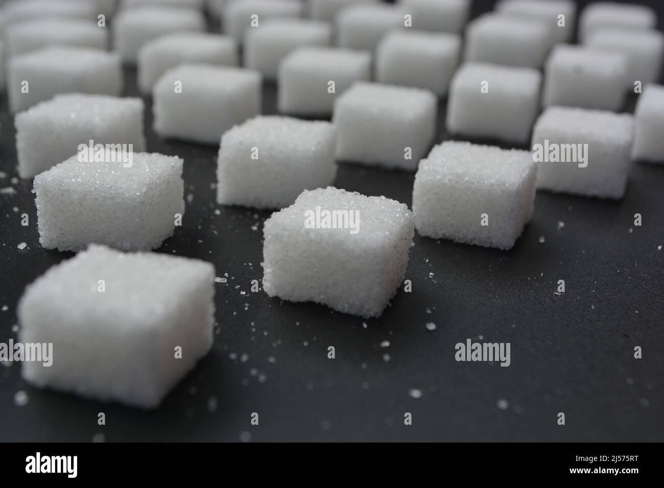 Motivo a cubetti di zucchero su sfondo grigio lucido. Stile astratto e minimalista. Foto Stock