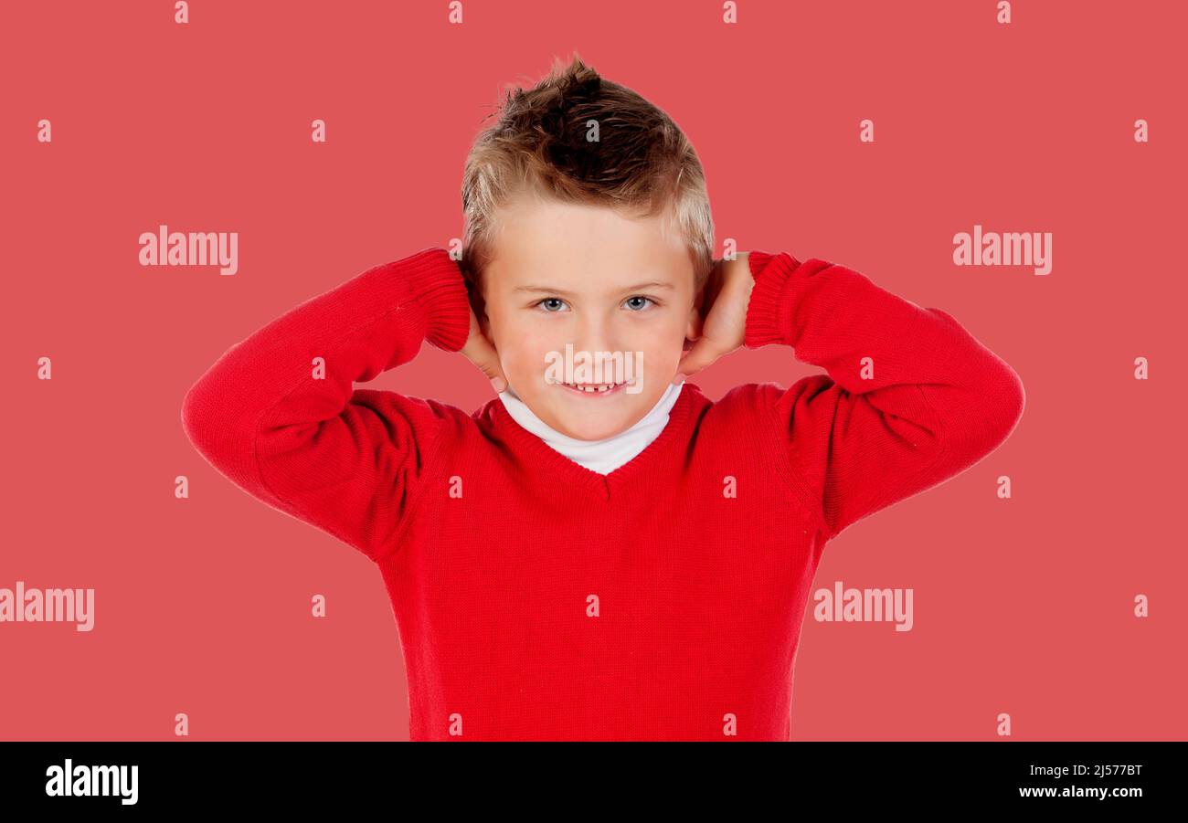 Il bambino infastidito di un forte rumore isolato su uno sfondo rosso Foto Stock