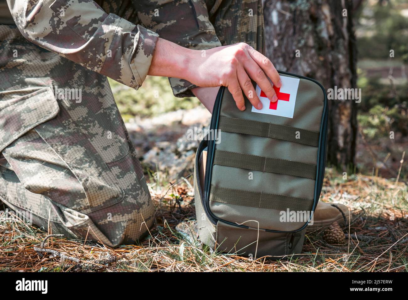 Kit di pronto soccorso militare. Medic del soldato camuffato. Cartello di pronto soccorso bianco e rosso. Foto Stock