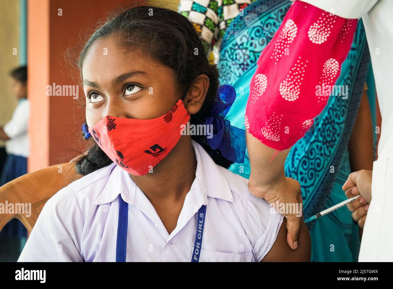 Vaccinazione in India, operatore medico che dà Sinopharm vaccino iniezione per proteggere da coronavirus o covid-19 ad una ragazza al Carmel High School for Girls in Baruipur, India Foto Stock