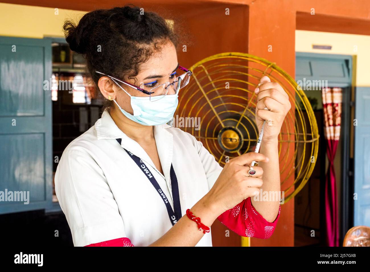 Vaccinazione in India, operatore medico che dà Sinopharm vaccino iniezione per proteggere da coronavirus o covid-19 ad una ragazza al Carmel High School for Girls in Baruipur, India Foto Stock