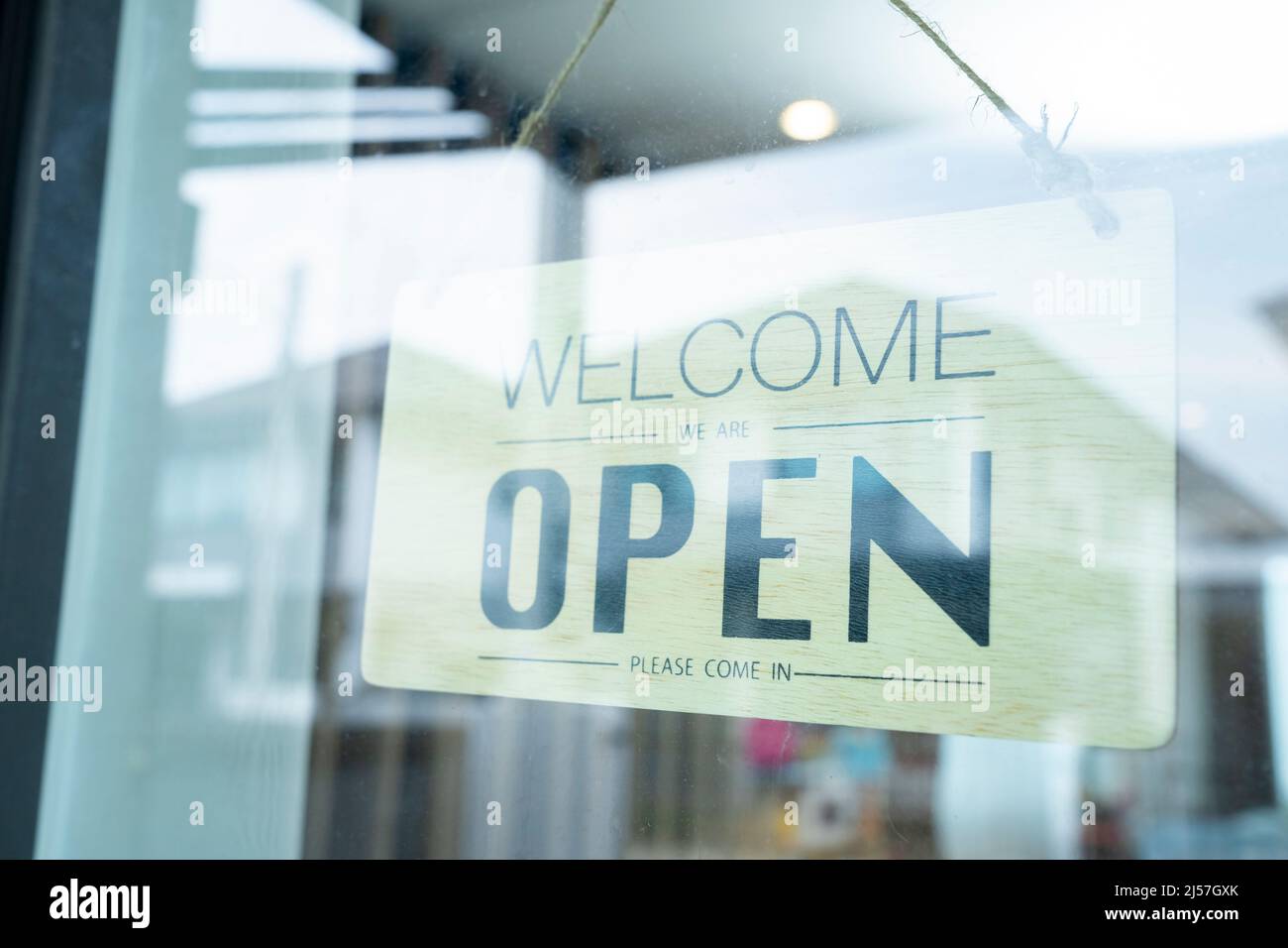 Cartello aperto appeso sulla porta di vetro Foto Stock