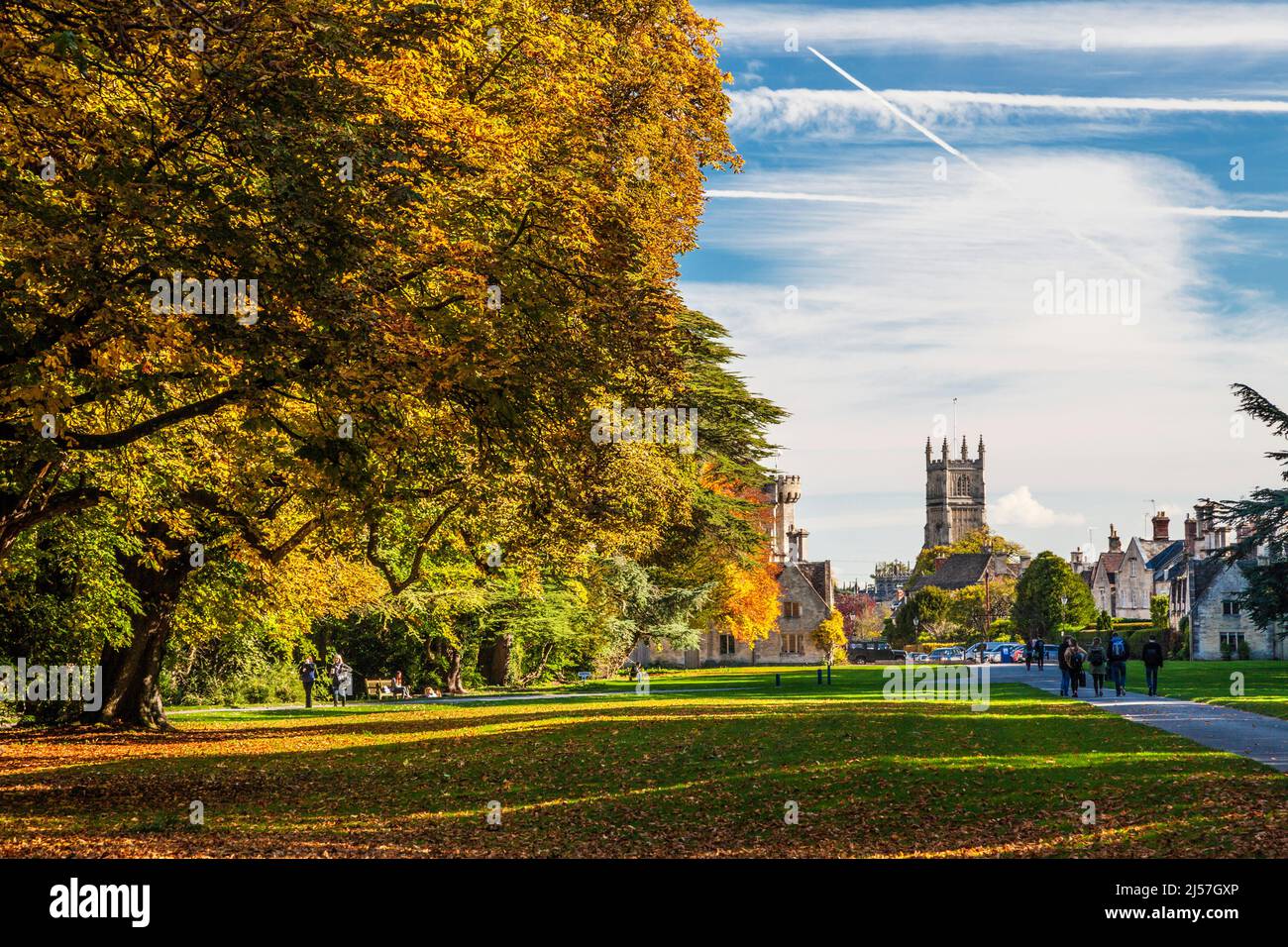 Splendidi colori autunnali al Cirencester Park sulla Bathurst Estate in Gloucestershire. La torre della Chiesa di Giovanni Battista e parte del Foto Stock