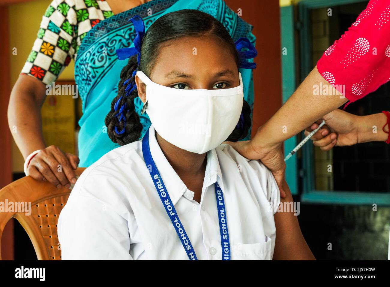 Vaccinazione in India, operatore medico che dà Sinopharm vaccino iniezione per proteggere da coronavirus o covid-19 ad una ragazza al Carmel High School for Girls in Baruipur, India Foto Stock