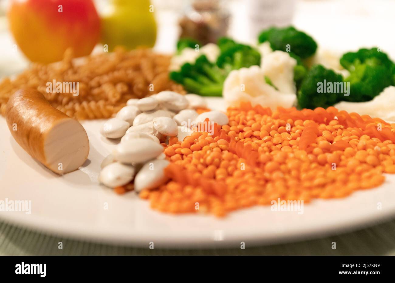 21 aprile 2022, bassa Sassonia, Osnabrück: Frutta, ortaggi, legumi, Grani interi e carne piccola sono su un piatto nella mostra 'Food. Cibo per il mondo di domani". Come il menù del giorno di domani, questo è presentato in mostra. La mostra fornisce approfondimenti sulla produzione alimentare e la ricerca nella regione di Osnabrück. La mostra sarà in mostra dal 24 aprile al 13 novembre 2022. Foto: Friso Gentsch/dpa Foto Stock