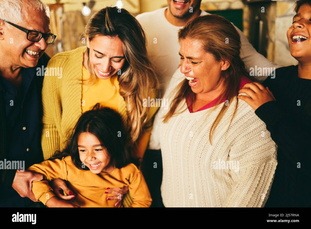 Felice famiglia latina sorridendo sulla macchina fotografica a casa - fuoco morbido sul fronte del ragazzo Foto Stock