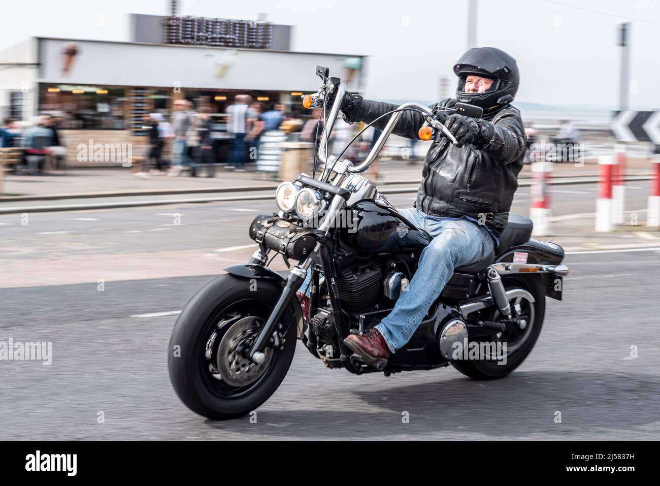 Il motociclista Harley Davidson arriva per il raduno motociclistico Southend Shakedown 2022 a Southend on Sea, Essex, Regno Unito. Jeans blu, pelle nera Foto Stock
