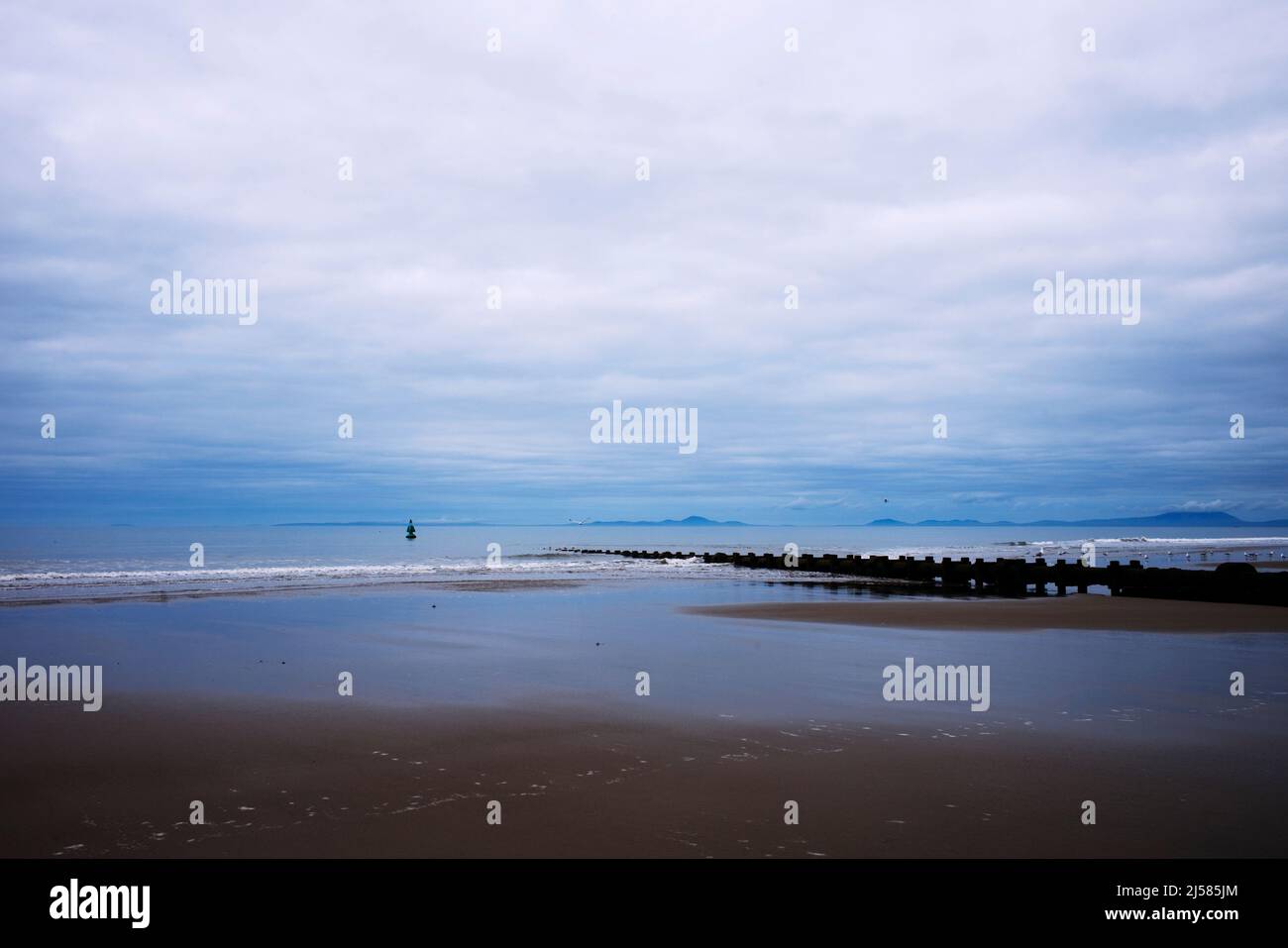 Un lungo tubo fognario che va in mare a Barmouth, Galles del Nord Foto Stock