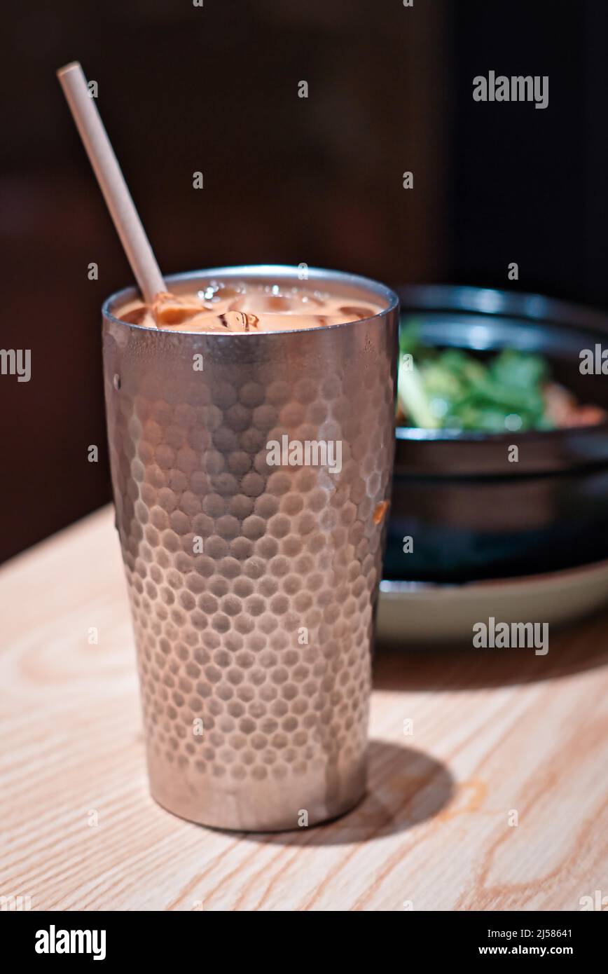 Tazza di metallo con tè al latte, tè al latte in stile Hong Kong nel ristorante Foto Stock