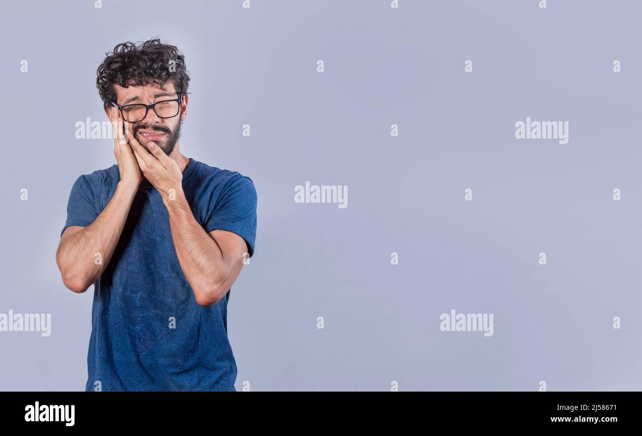Ragazzo attraente con mal di denti, immagine isolata dell'uomo con mal di denti, mano sulla guancia con mal di denti Foto Stock