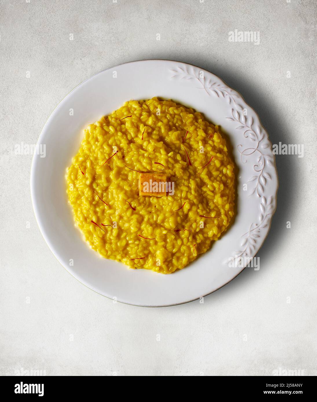 Risotto alla milanese condito con fili di zafferano e parmigiano reggiano. Foto Stock