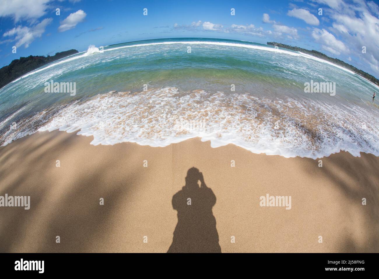 Onde e surf su Hanalei Beach sull'isola di Kauai, Hawaii, Stati Uniti. Fotografato con una lente fisheye che crea un'immagine distorta. Foto Stock