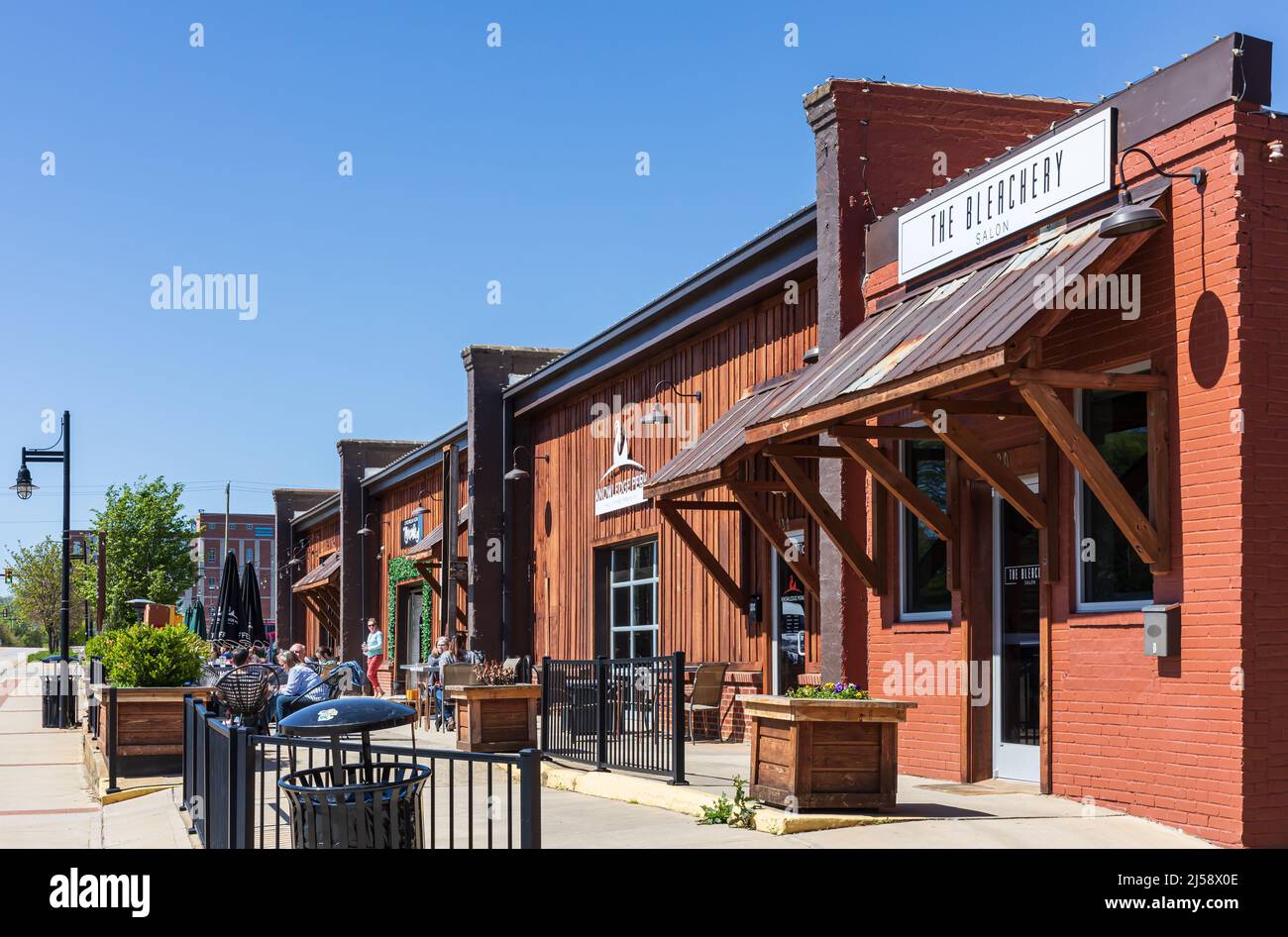 ROCK HILL, SC, USA-10 APRILE 2022: Negozi di specialità nel centro cittadino con posto sul marciapiede esterno e ristoranti. Giorno di primavera soleggiato, gente. Foto Stock