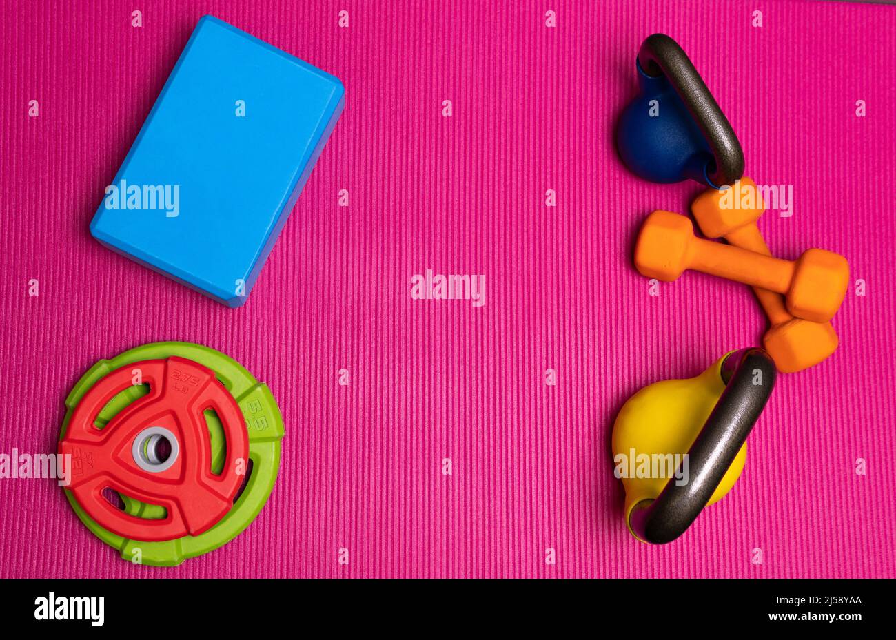 Yoga Kettlebell verde spazio tappeto sfondo rosso sport esercizio, da allenamento dumbbell in concetto da attività colorata, testo in alto. Promemoria allungare a casa Foto Stock