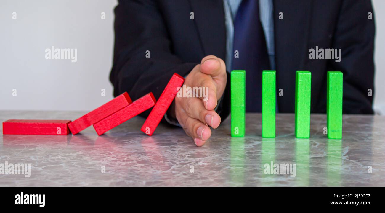 L'uomo d'affari sta bloccando la caduta dei blocchi di legno. Concetto di gestione delle crisi. Trovare la soluzione al problema. Strategia per il business. Foto Stock