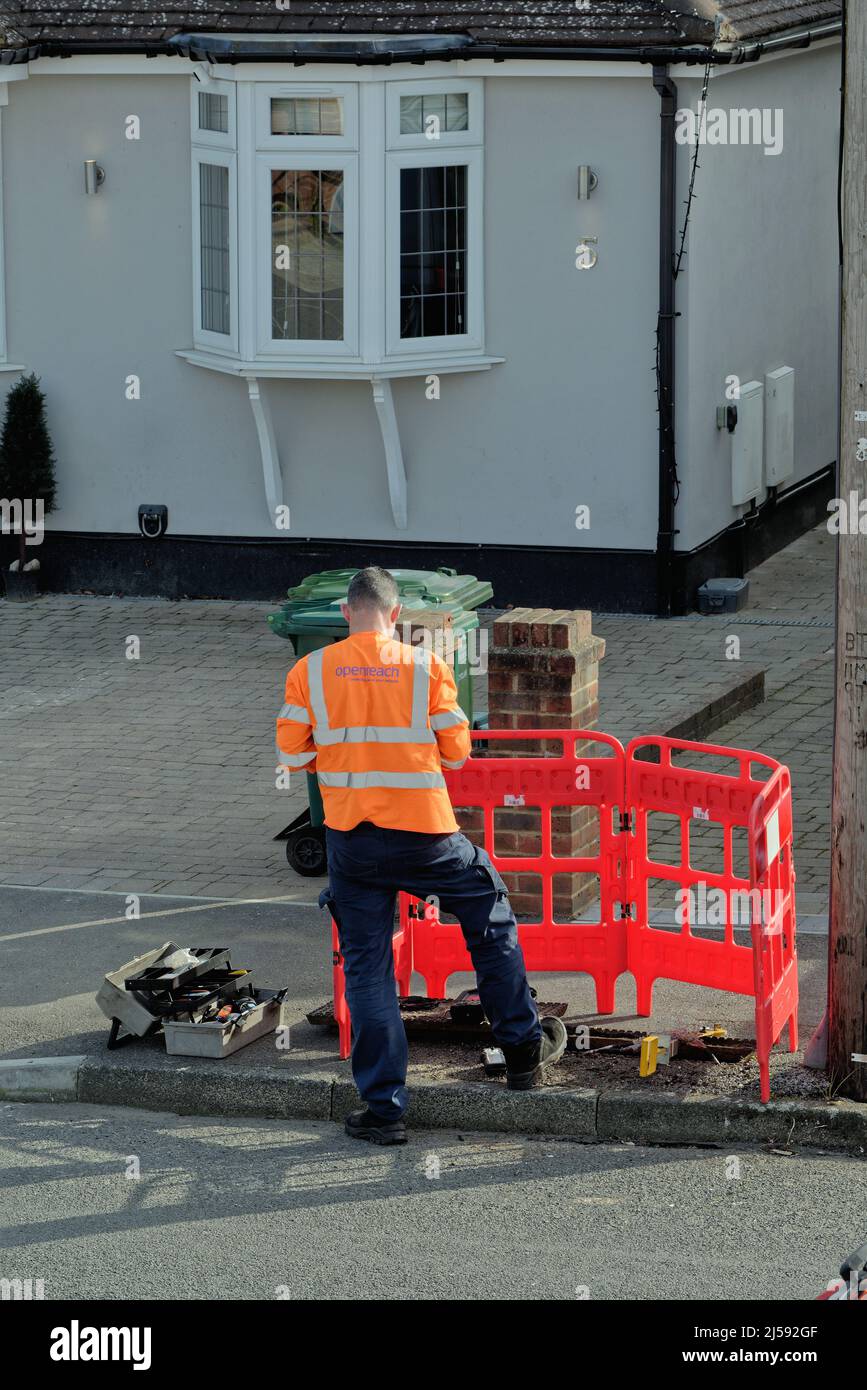 Un ingegnere di comunicazione BT Openreach che lavora su una linea telefonica in una strada suburbana Surrey Inghilterra Regno Unito Foto Stock