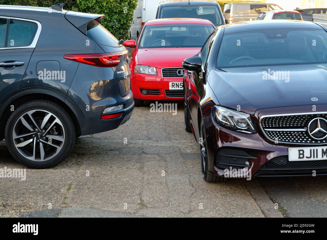 Tre auto mal parcheggiate che bloccano l'accesso a un marciapiede pedonale su una strada suburbana, Inghilterra Regno Unito Foto Stock