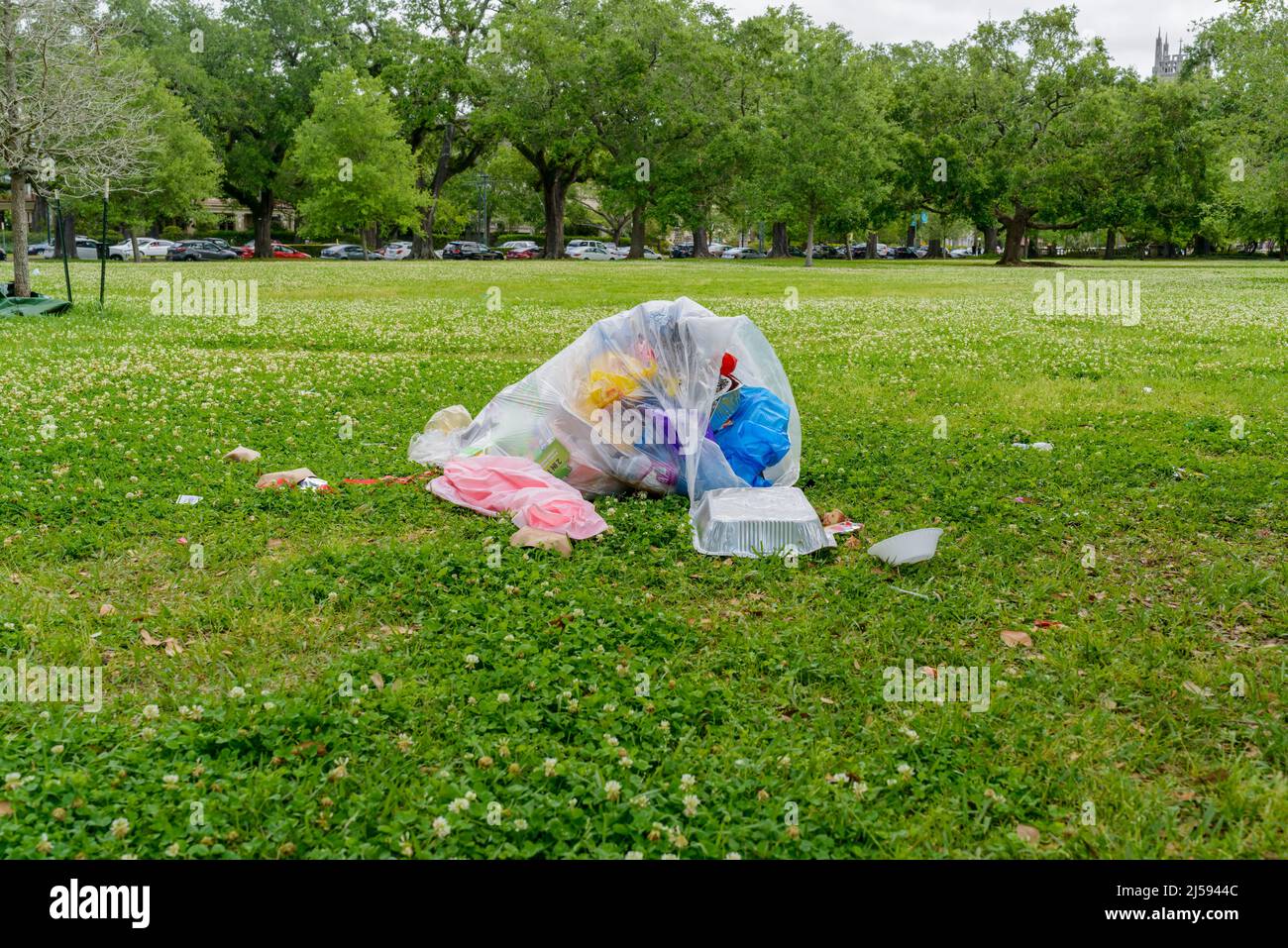 Apri il sacco di spazzatura con la spazzatura fuoriuscendo a sinistra dopo il pic-nic Domenica di Pasqua in Audubon Park a New Orleans, LA, Stati Uniti d'America il 18 aprile 2022 Foto Stock