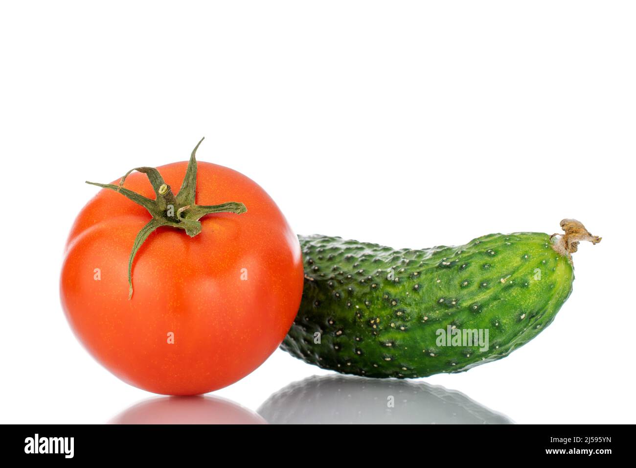 Un pomodoro maturo e cetriolo, macro, isolato su sfondo bianco. Foto Stock