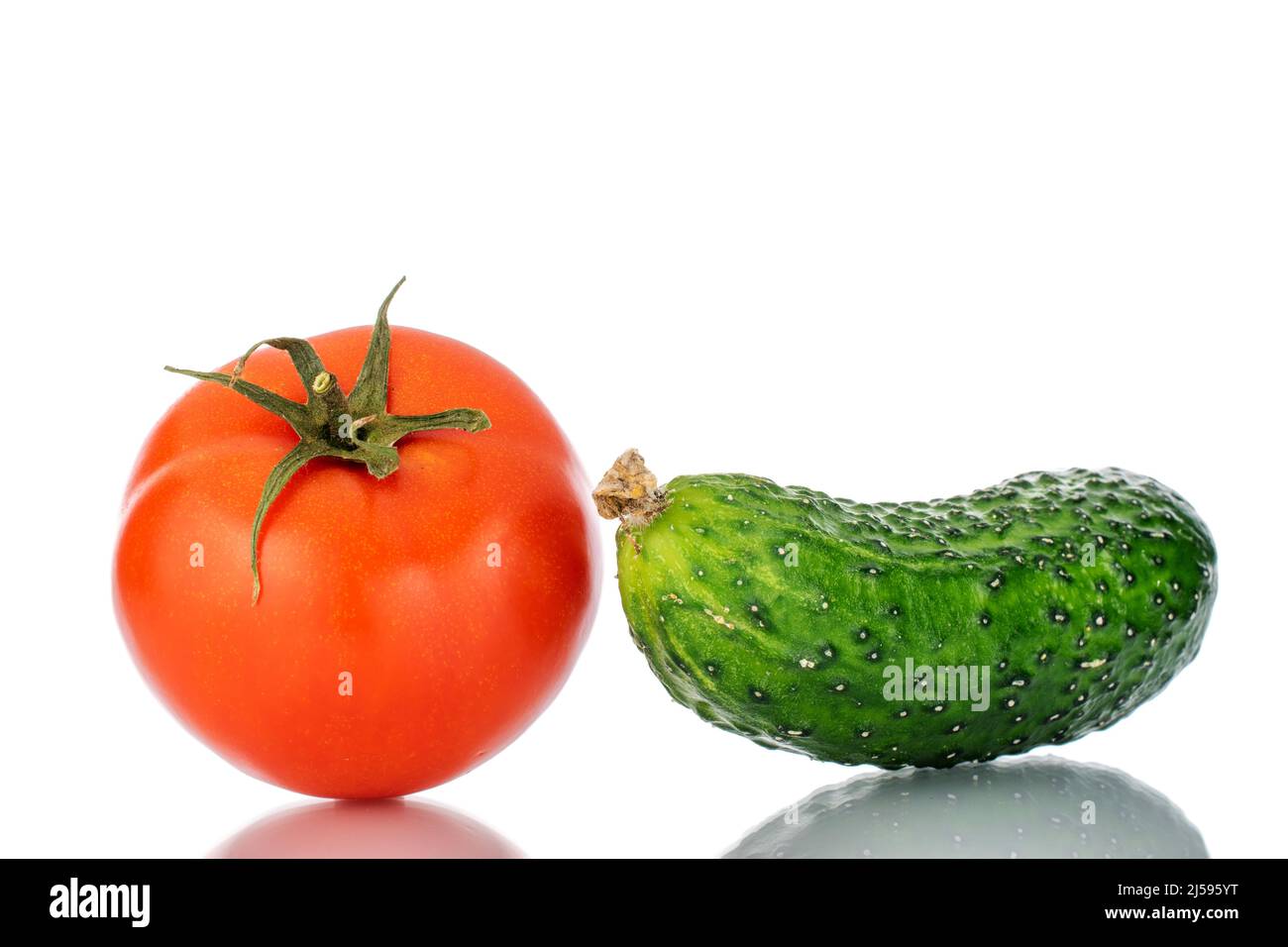 Un pomodoro maturo e cetriolo, macro, isolato su sfondo bianco. Foto Stock
