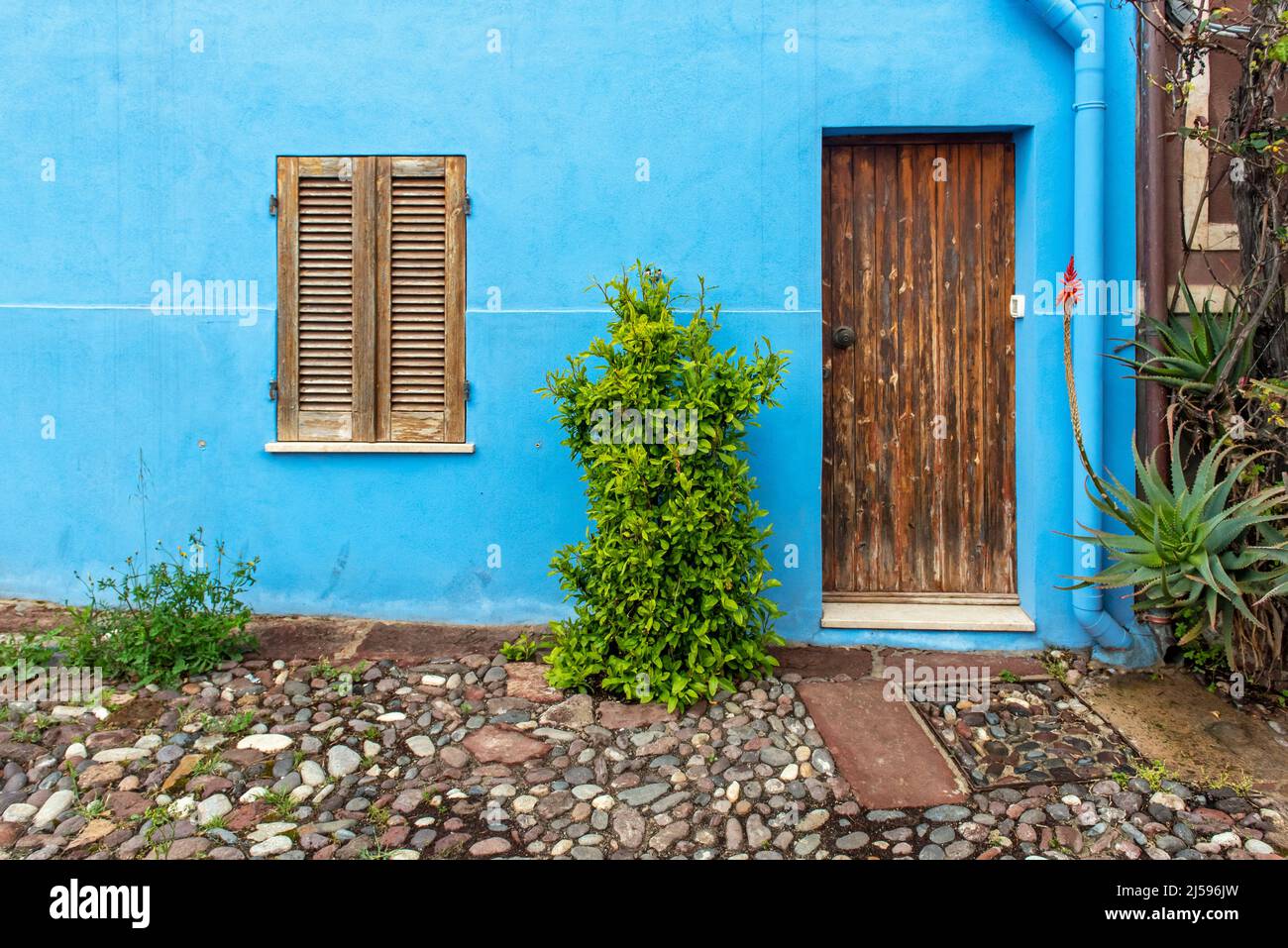 Porta e finestra in legno su parete blu, Bosa, Sardegna, Italia Foto Stock