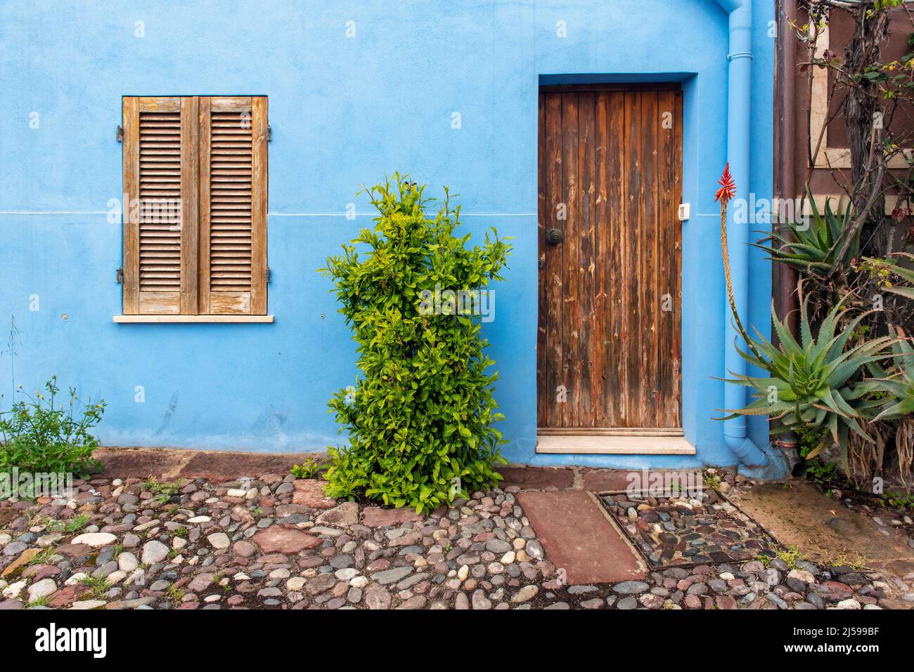 Porta e finestra in legno su parete blu, Bosa, Sardegna, Italia Foto Stock