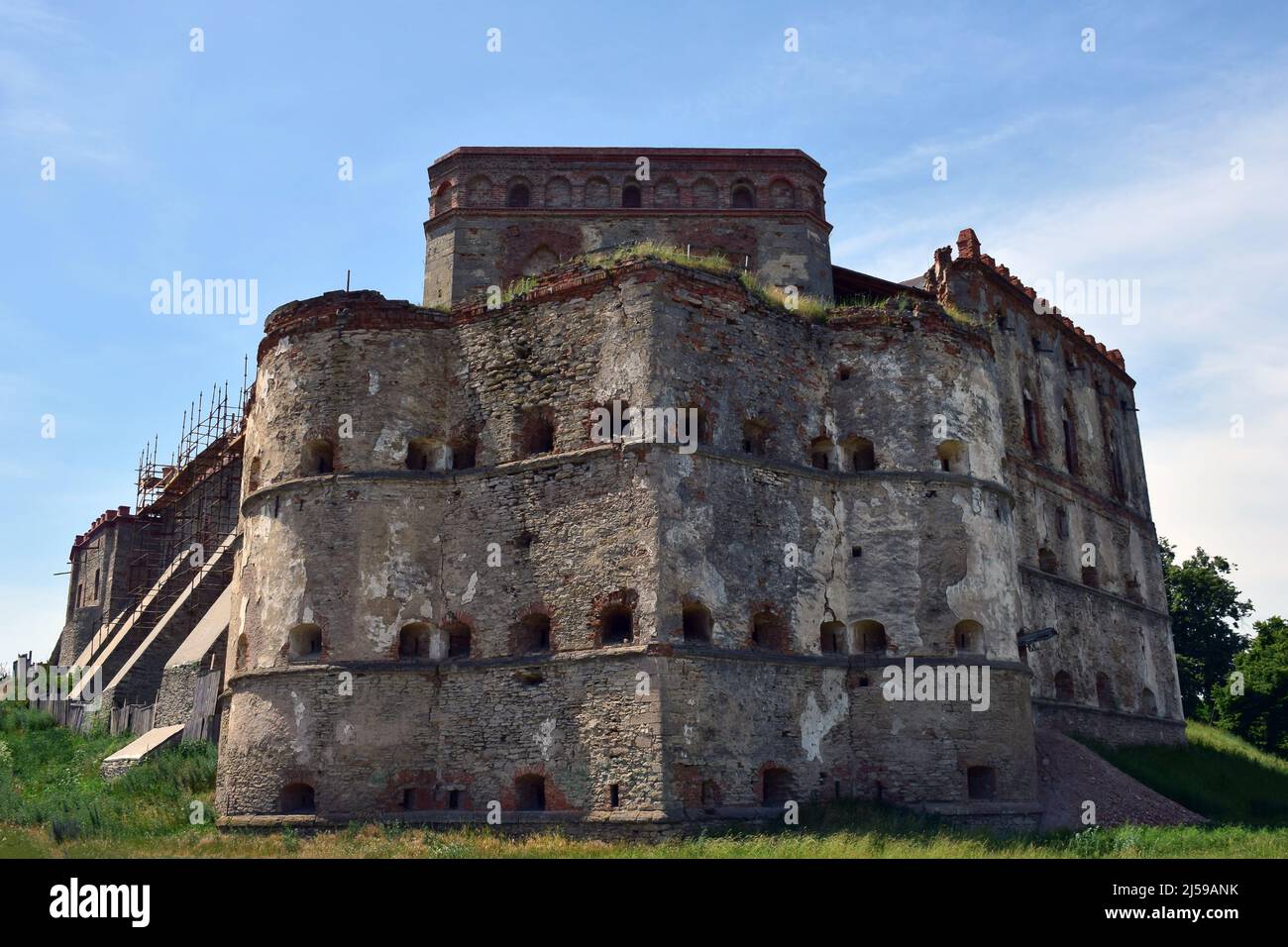 Un'enorme fortezza medievale in pietra abbandonata in diversi piani con scappatoie e abbracci Foto Stock