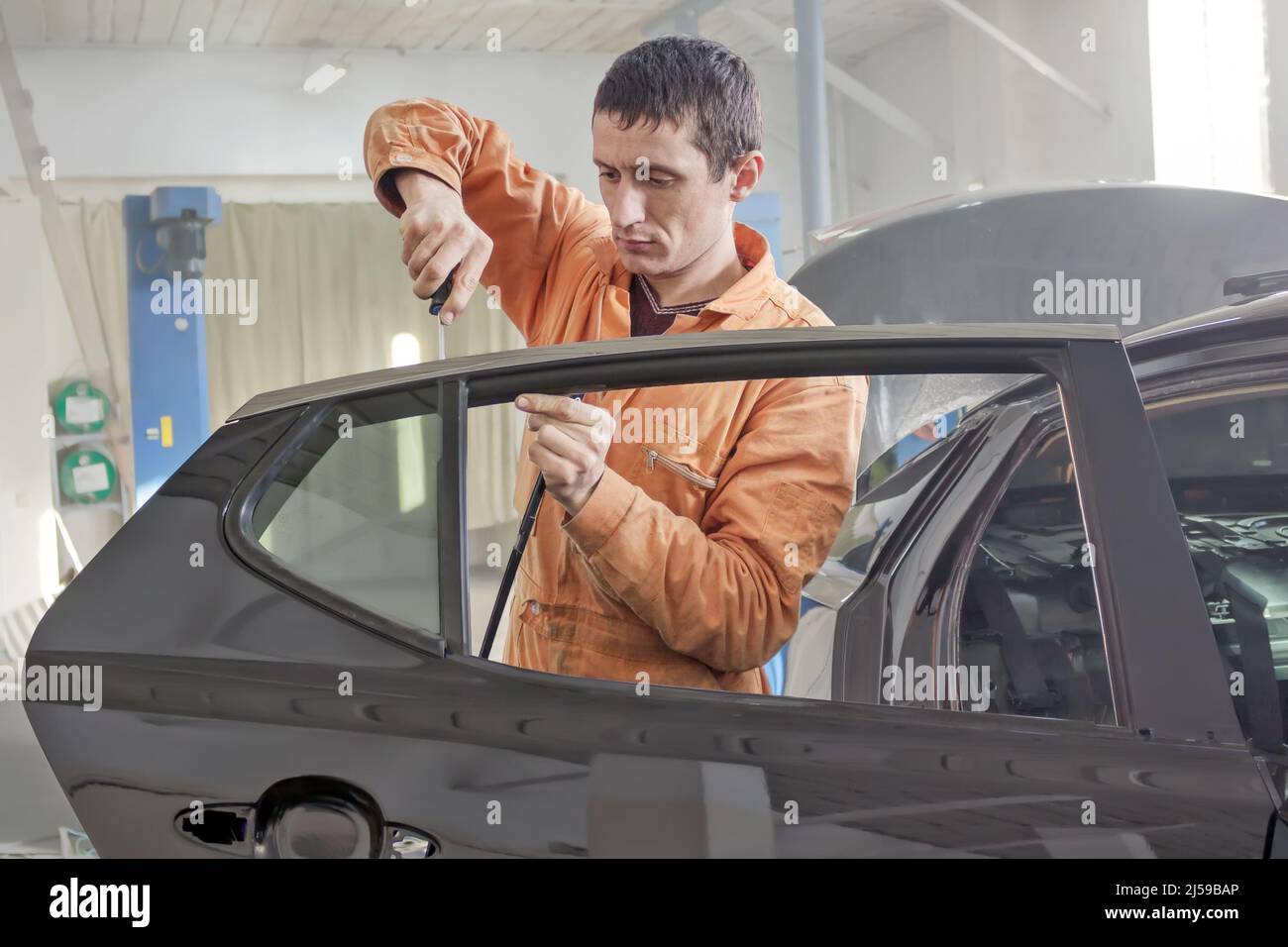 Il lavoratore di servizio auto smonta la porta dell'auto per la