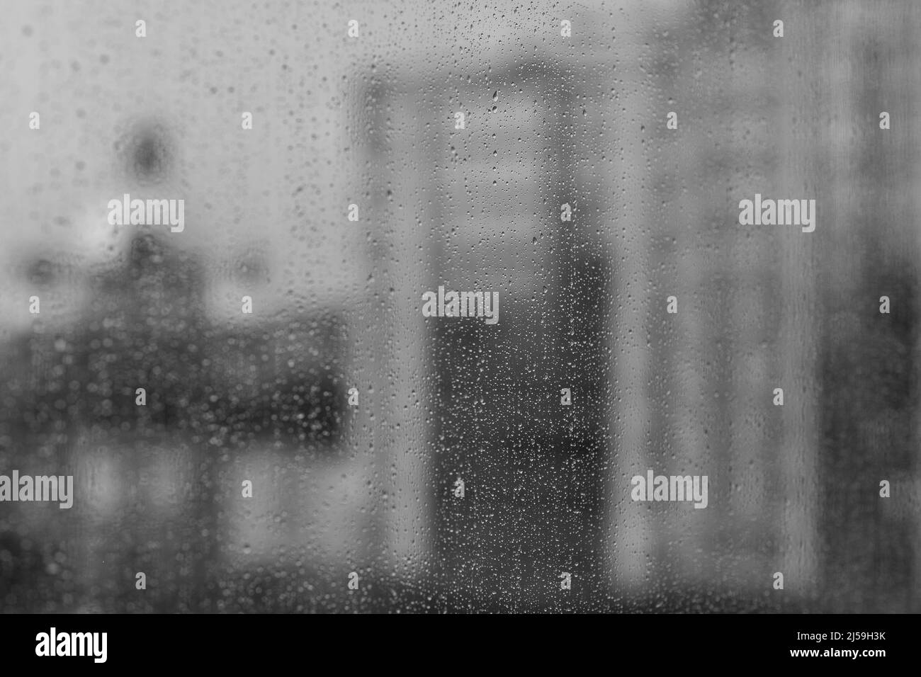Grandi gocce di pioggia sul vetro a fuoco, finestra, funivia in nebbia, un phonikuler sfocato, fuori fuoco. Gocce di pioggia sulla superficie dei vetri della finestra con ba nuvolosa Foto Stock