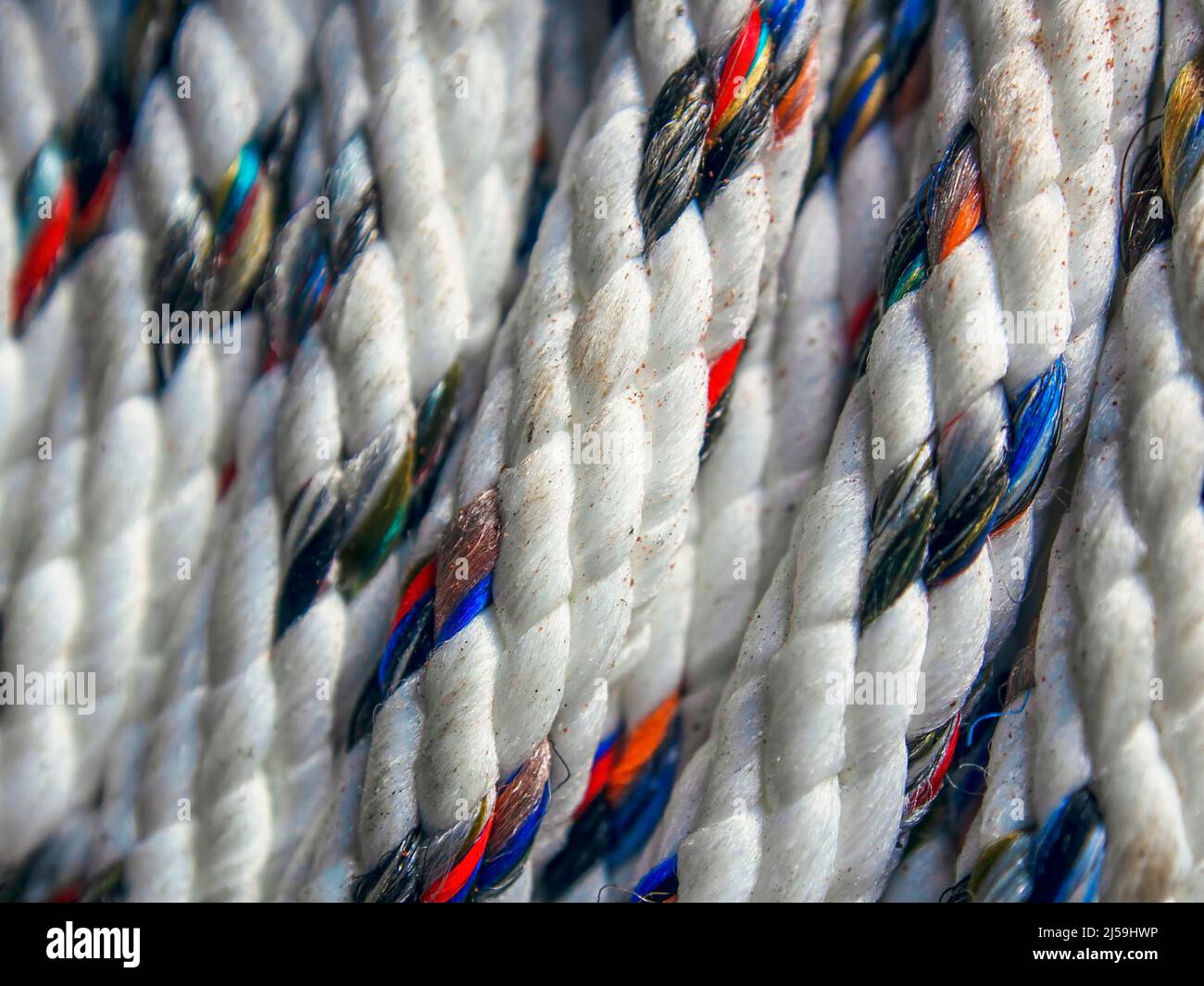 Macro fotografia di una corda di nylon bianco macchiato di colore Foto Stock