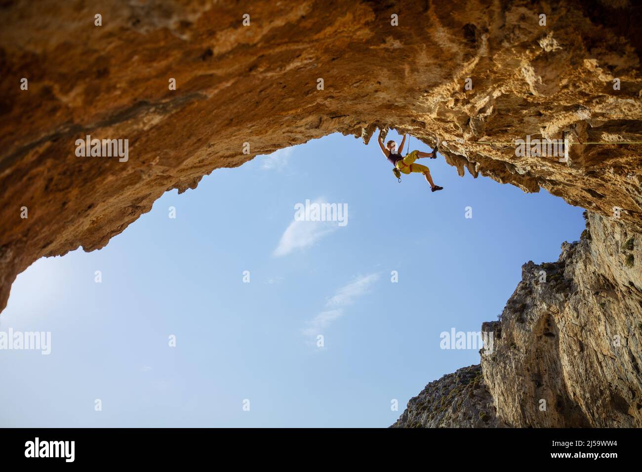 Scalatore di roccia femminile su percorso impegnativo in grotta Foto Stock