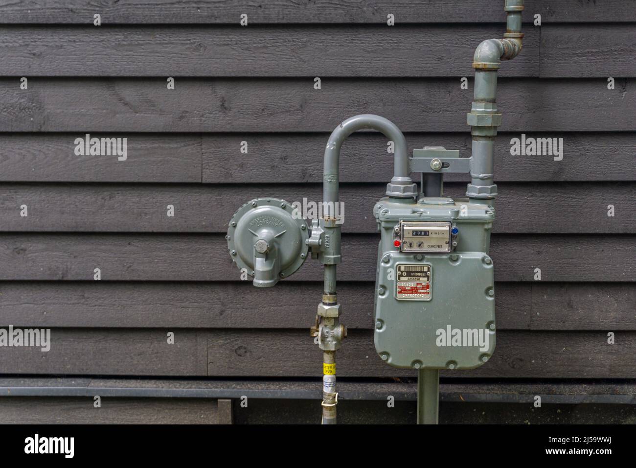 Ontario, Canada, agosto 2021 - contatore di gas e tubi di collegamento contro un muro di legno di una casa Foto Stock