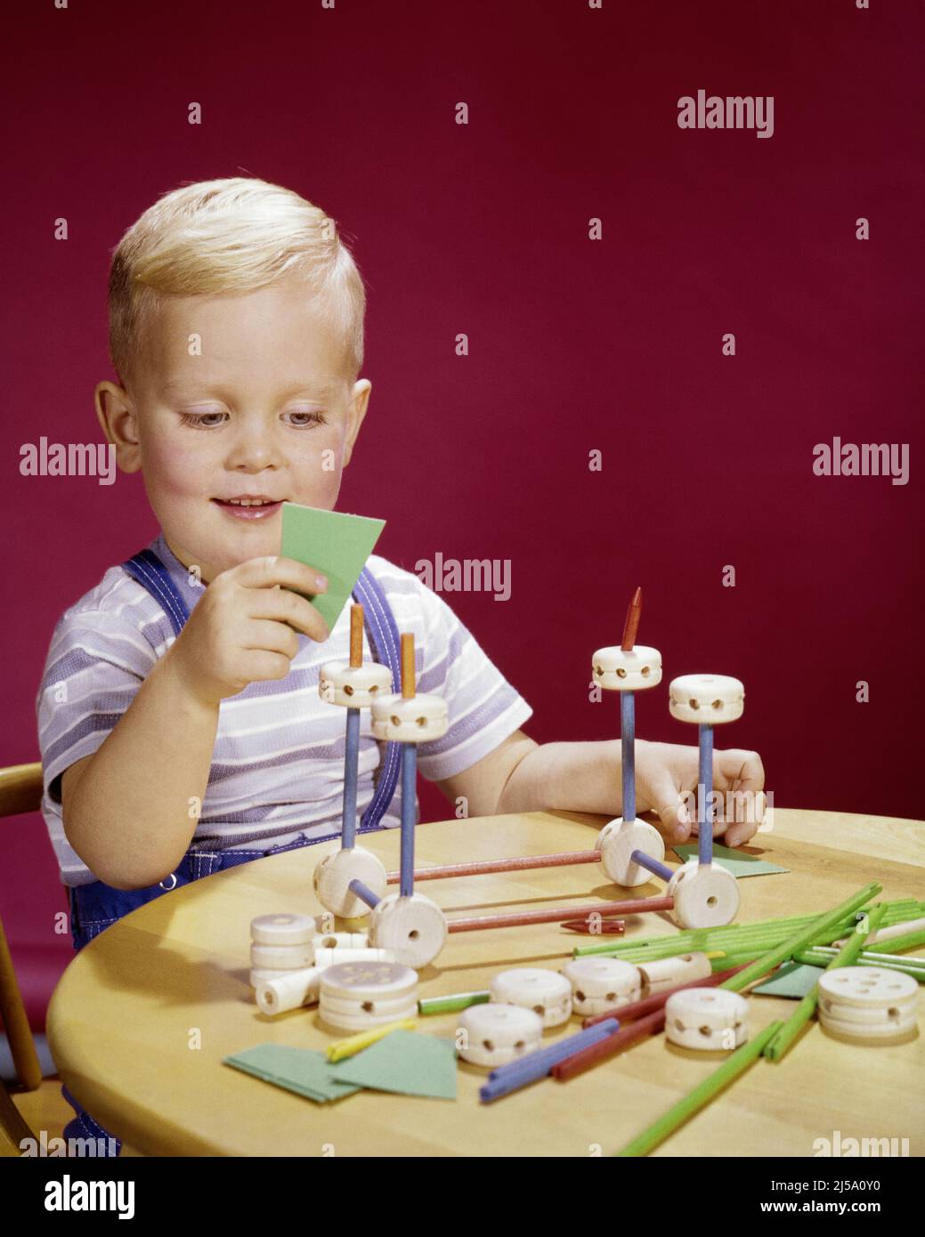 1960S RAGAZZO BIONDO SORRIDENTE CHE GIOCA CON UN SET DA COSTRUZIONE TINKERTOY CHE METTE INSIEME PEZZI COSTRUIRE QUALCOSA - KJ3246 HAR001 HARS HOME VITA COPIA SPAZIO HALF-LENGTH MASCHI FIDUCIA PEZZI LIBERTÀ FELICITÀ ALLEGRIA SCOPERTA ECCITAZIONE CONOSCENZA PROGRESSO RICREAZIONE ORGOGLIO OPPORTUNITÀ SORRISI CONNESSIONE CONCETTUALE IMMAGINAZIONE GIOIOSA QUALCOSA CREATIVITÀ IDEE DI CRESCITA GIOVANI RILASSAMENTO TINKER TOY ETNIA CAUCASICA HAR001 VECCHIO STILE Foto Stock