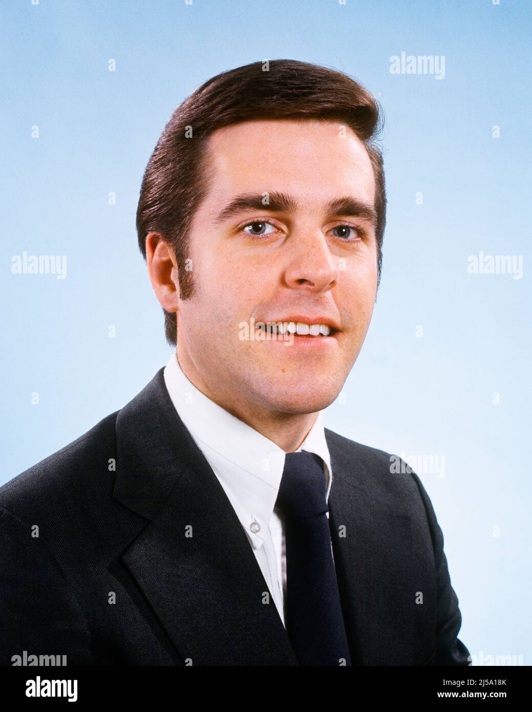 1970S RITRATTO DI SORRIDENTE GIOVANE BRUNA UOMO D'AFFARI IN ABITO E CRAVATTA GUARDANDO LA MACCHINA FOTOGRAFICA - KP1921 HAR001 HARS ALLEGRO ONESTO ORGOGLIO VISO CAPELLI SORRISI GIOIOSO PIACEVOLE MEDIO-ADULTO UOMO BASETTE CAUCASICO ETNIA HAR001 VECCHIO STILE Foto Stock