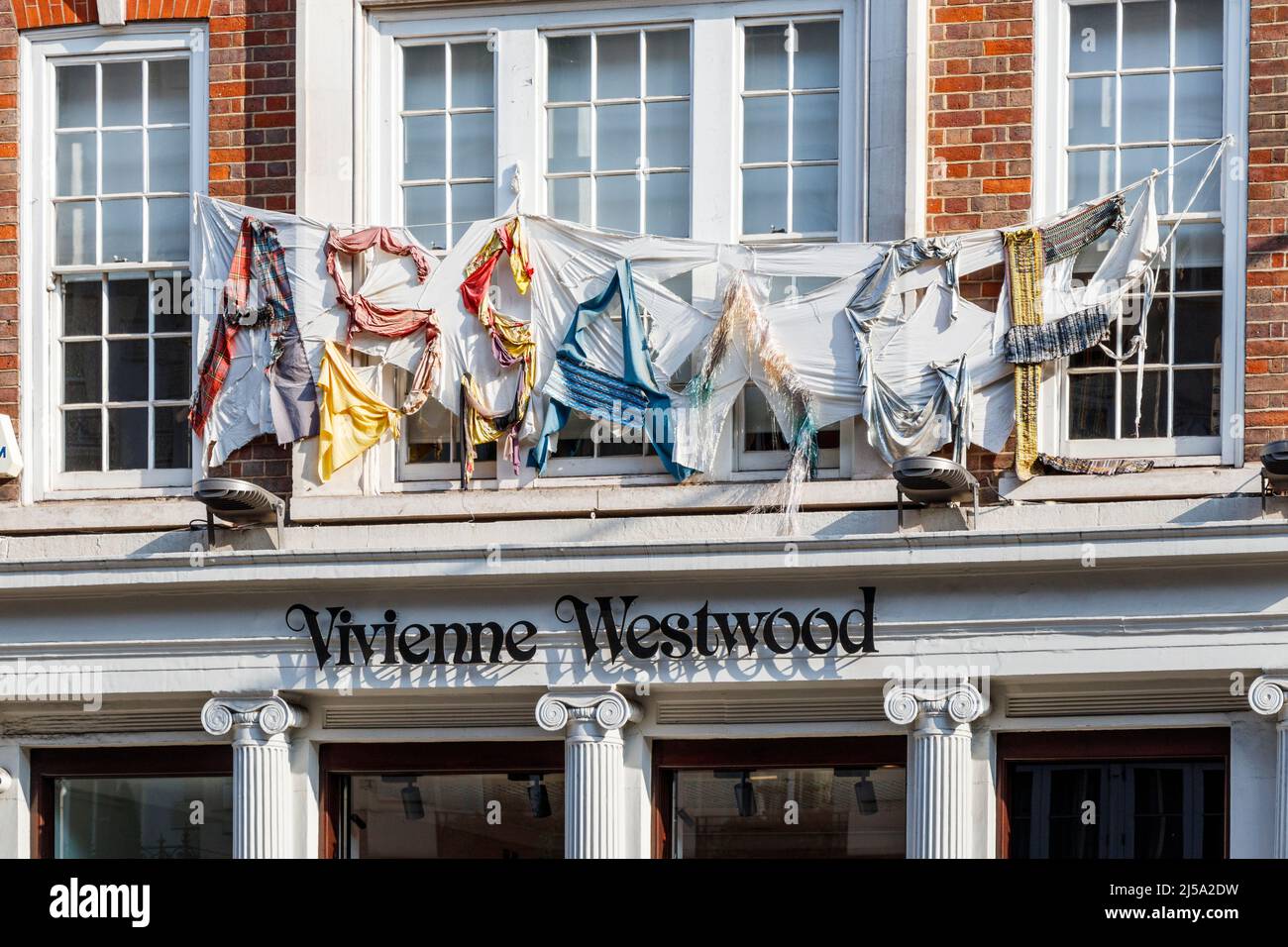 Il nome 'Assange' fatto da resti di tessuto sopra il negozio Vivienne Westwood Flagship in Conduit Street nella zona Mayfair di Londra, Regno Unito Foto Stock