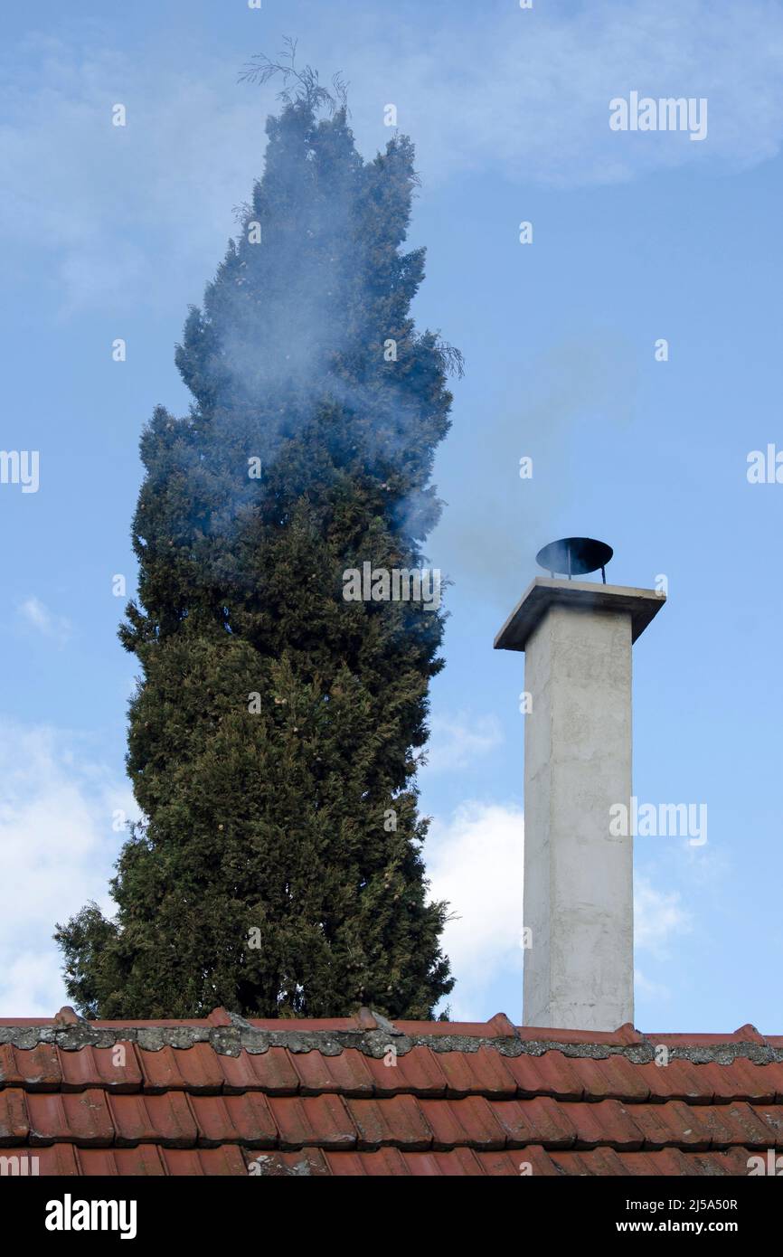 Camino Smokey a metà inverno su cielo blu Foto Stock