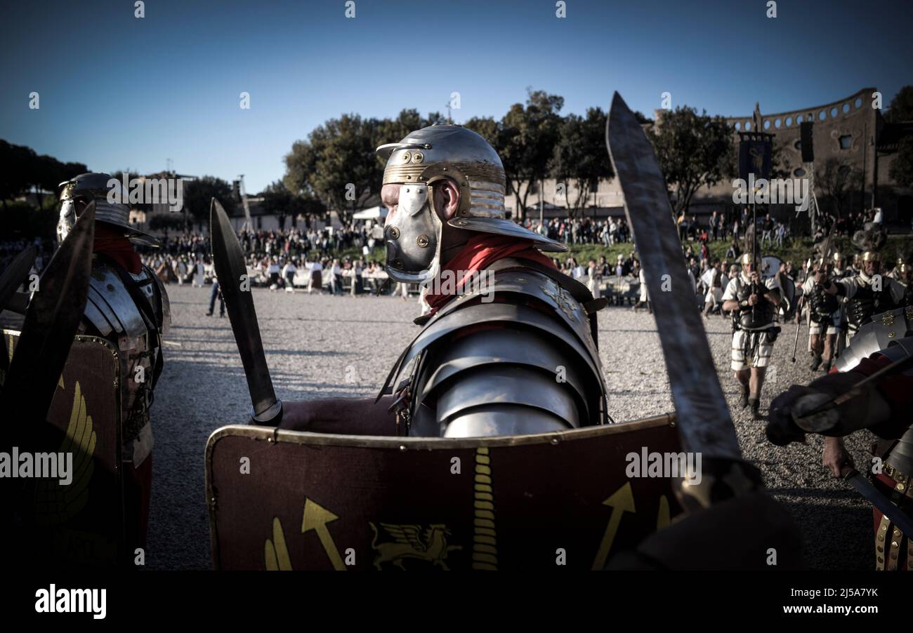 Soldati romani in una rievocazione storica nel mese di aprile. Persone che eseguono una legione romana e spade barbariche attraversate al Colosseo, Circo massimo Foto Stock