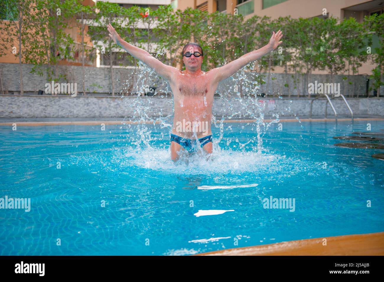 nuotatore sportivo che salta in piscina Foto Stock