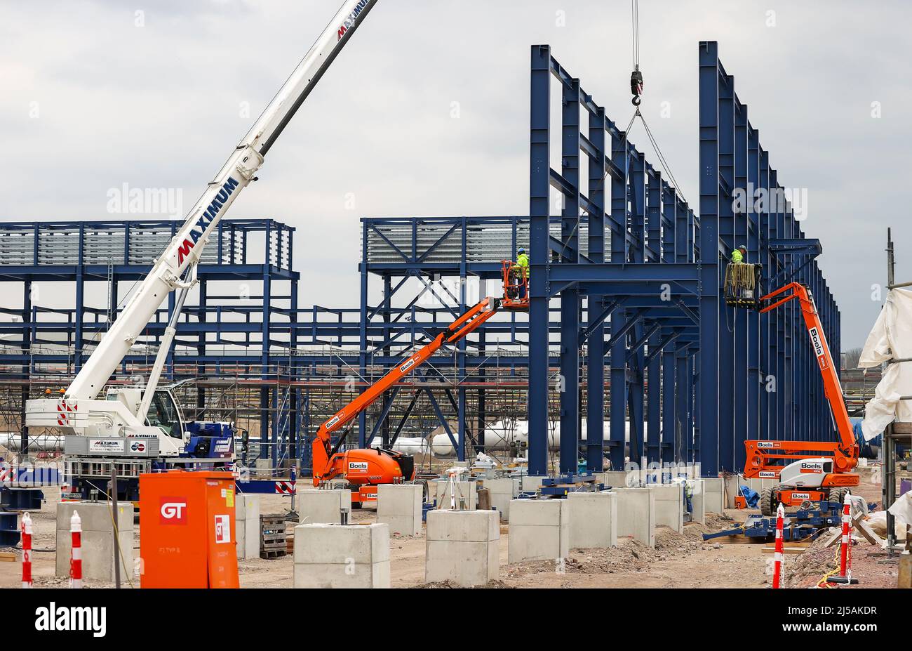 Leuna, Germania. 20th Apr 2022. I lavoratori assemblano ponti blu come la spina dorsale della futura biorefineria UPM. A partire dal 2023, la società finlandese intende produrre materie prime chimiche a base di legno per imballaggi, parti di automobili e suole per calzature. A tal fine saranno investiti 550 milioni di euro e 220.000 tonnellate metriche di prodotti saranno prodotte ogni anno. (Vista aerea con drone) Credit: Jan Woitas/dpa/Alamy Live News Foto Stock