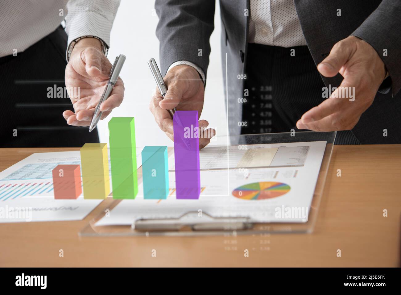 Gli uomini d'affari asiatici che interagiscono con la realtà aumentata grafico a barre tridimensional mentre analizzano un ritorno sugli investimenti e le prestazioni aziendali Foto Stock