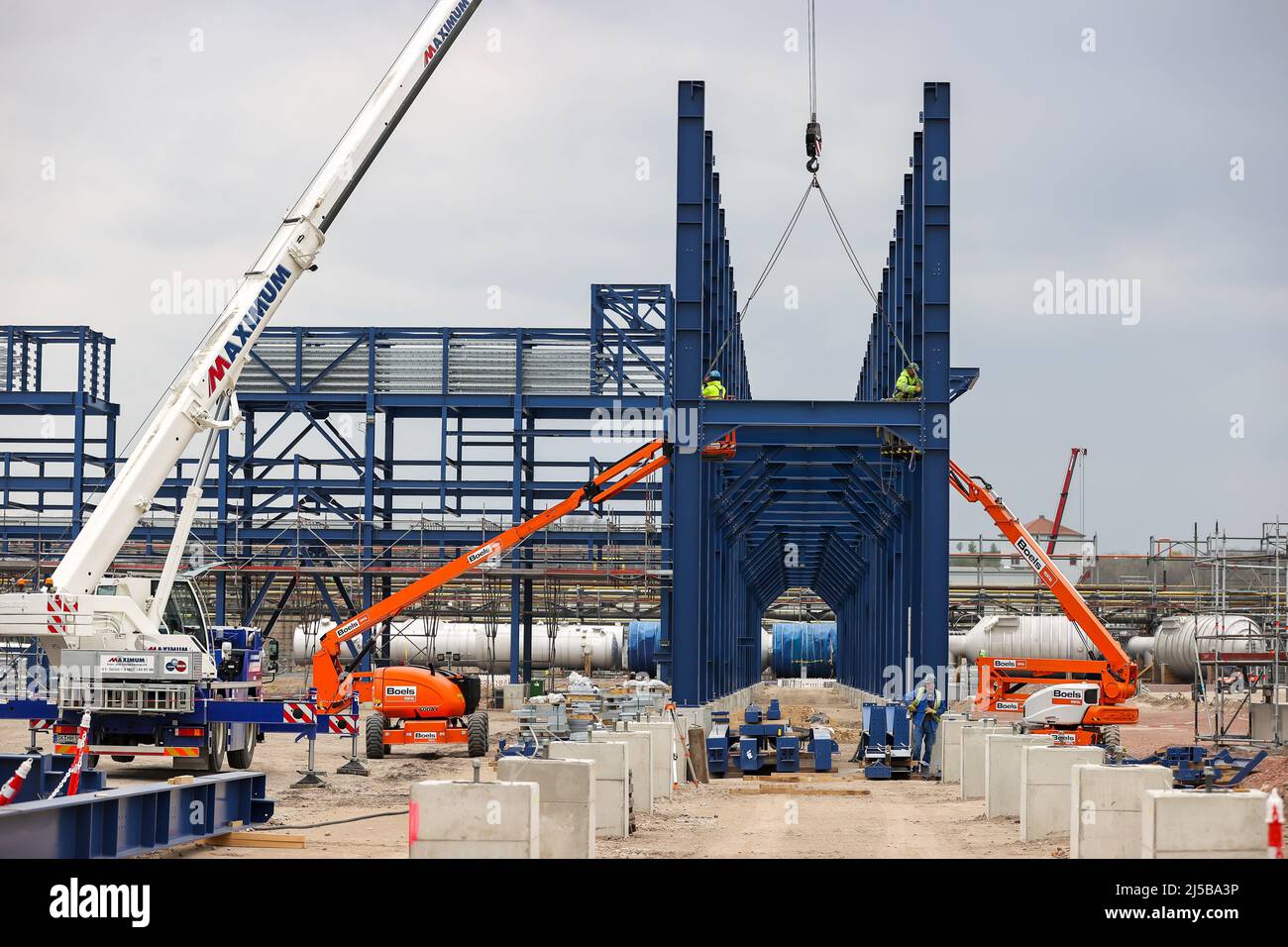 Leuna, Germania. 20th Apr 2022. I lavoratori assemblano ponti blu come la spina dorsale della futura biorefineria UPM. A partire dal 2023, la società finlandese intende produrre materie prime chimiche a base di legno per imballaggi, parti di automobili e suole per calzature. A tal fine saranno investiti 550 milioni di euro e 220.000 tonnellate metriche di prodotti saranno prodotte ogni anno. Credit: Jan Woitas/dpa/Alamy Live News Foto Stock