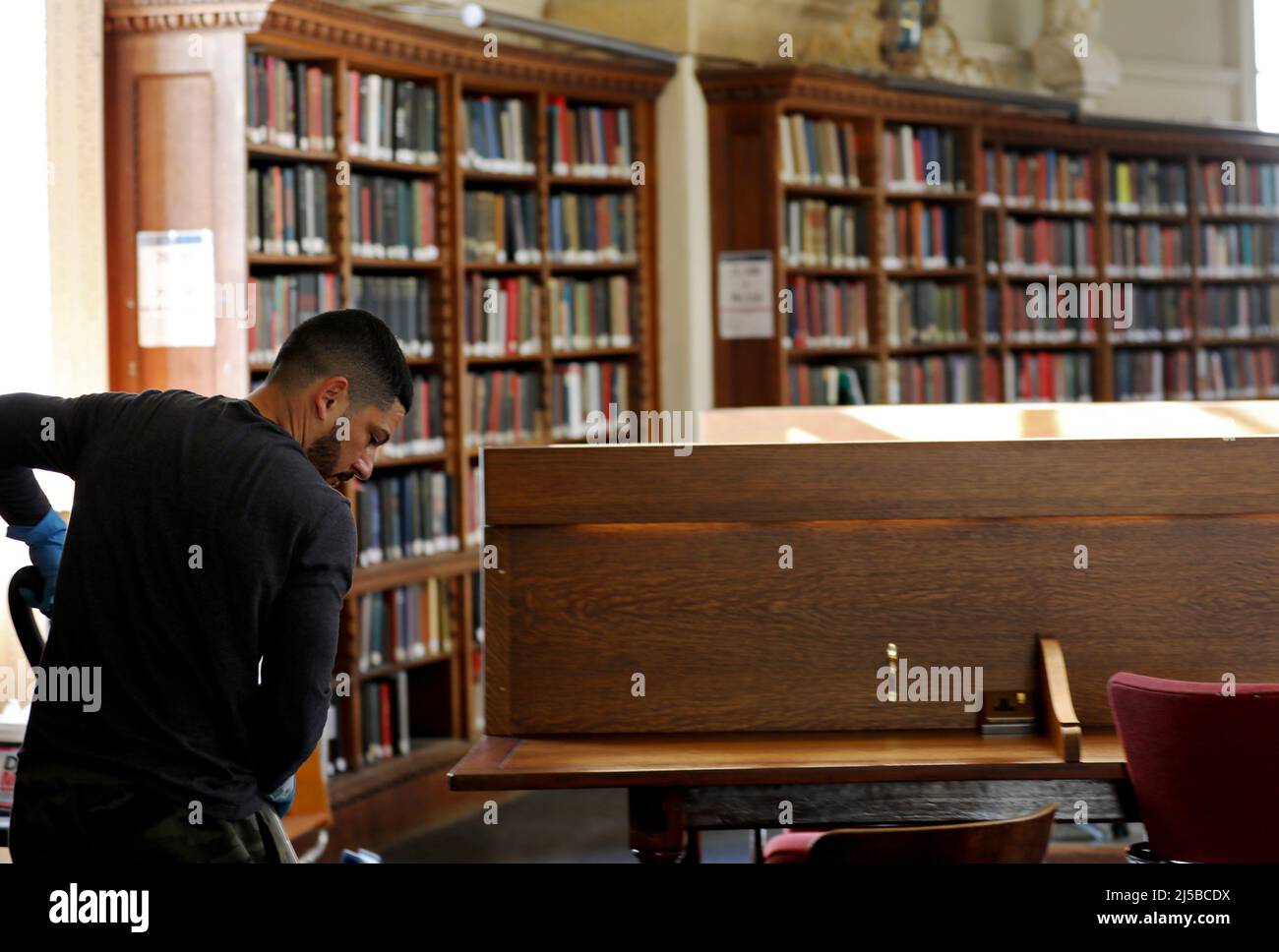 Oxford, Regno Unito. 21st Apr 2022. (220422) -- OXFORD, 22 aprile 2022 (Xinhua) -- un membro del personale pulisce il pavimento nelle biblioteche Bodleiane dell'Università di Oxford, Gran Bretagna, 21 aprile 2022. Come servizio di biblioteca che sostiene l'Università di Oxford, le biblioteche Bodleian includono la biblioteca principale dell'università, la biblioteca Bodleian, che è stata una biblioteca del deposito legale per 400 anni, così come altre 27 biblioteche attraverso Oxford compreso le biblioteche e le biblioteche principali della facoltà di ricerca, del reparto e dell'istituto. Insieme, le Librerie contengono più di 13 milioni di articoli stampati, oltre 80.000 riviste elettroniche A. Foto Stock