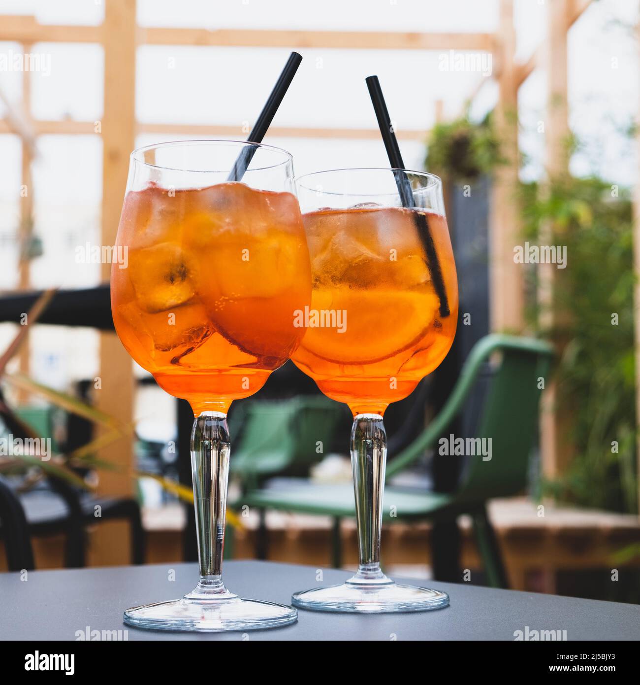 Due bicchieri di Aperol Spritz serviti sulla terrazza del moderno bar.  Famoso cocktail a base di vino italiano e aperitivo estivo bevanda  rinfrescante preparato wi Foto stock - Alamy