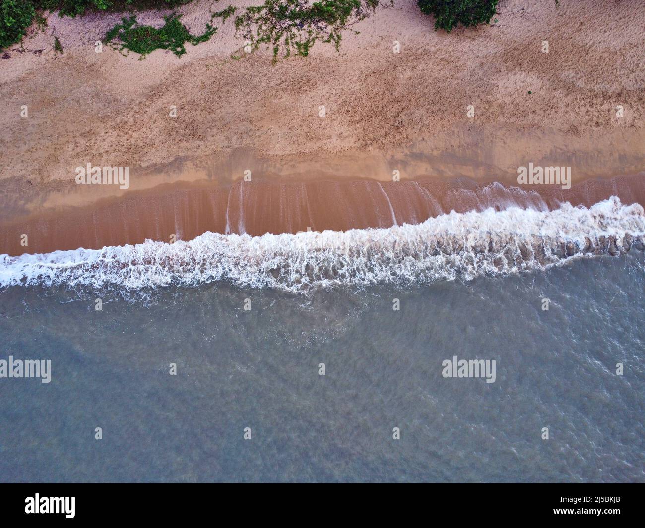 Un colpo di onde che si infrangono contro la spiaggia Foto Stock