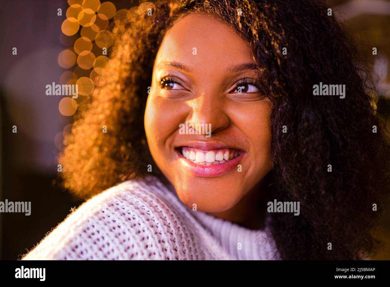 Donna felice sullo sfondo di una ghirlanda di lampade Natale e Capodanno concetto Foto Stock