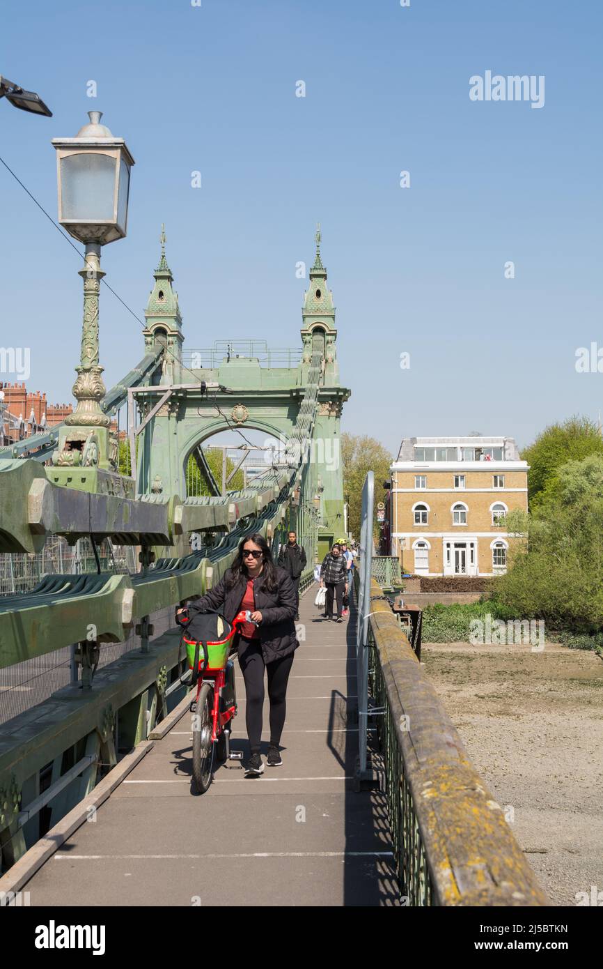 Ciclisti e pedoni che si muovono per lo spazio mentre attraversano Hammersmith Bridge a causa di riparazioni e manutenzione in corso Foto Stock