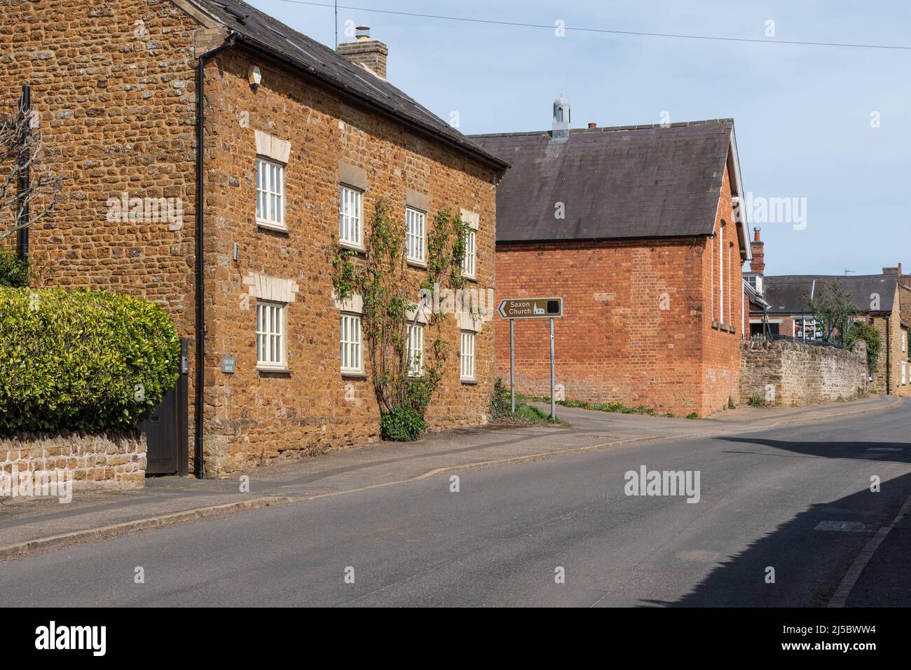 Scena di strada con vecchi cottage in pietra nel villaggio di Brixworth, Northamptonshire, Regno Unito Foto Stock