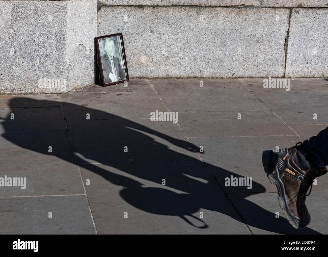 Londra, Regno Unito. 21st Apr 2022. Un'immagine dell'omicidio del deputato Sir David Amess si trova ingiallito e piuttosto trascurato sul marciapiede proprio accanto alle porte d'ingresso principali del Parlamento, pochi mesi dopo che un servizio commemorativo è stato tenuto presso l'Abbazia di Westminster. La gente cammina oltre la fotografia, che in passato ha avuto fiori e omaggi accanto ad essa apparentemente ignari di essere lì. Amess è stato fatalmente rubato nel suo ufficio elettorale da un aggressore nell'ottobre 2021. Credit: Imagplotter/Alamy Live News Foto Stock